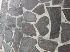 四角石のタイルの中にハートのタイルがある写真